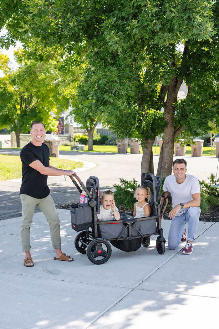 dad pushing two kids in a stroller wagon in airport