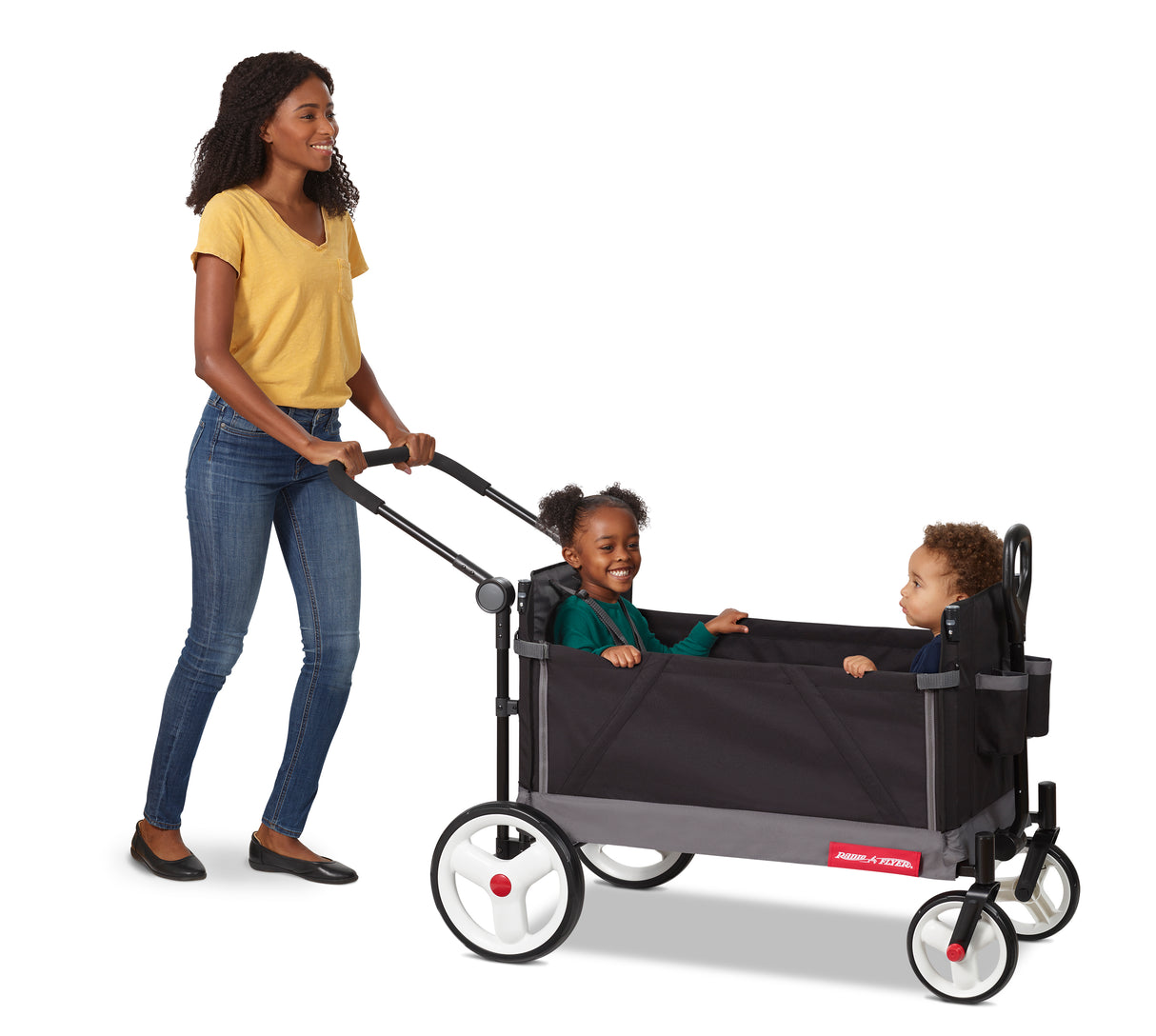 Mom pushing the black folding wagon with two toddlers riding in it