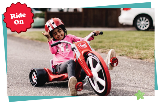 Child riding a red tricycle.