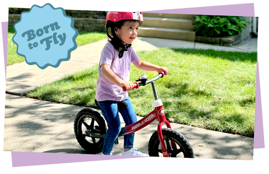 Child riding a balance bike with 'Born to Fly' text overlay