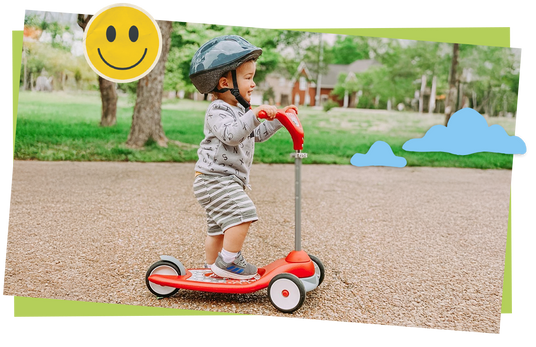 Child riding a scooter in a park with a smiley face sticker and blue clouds added.